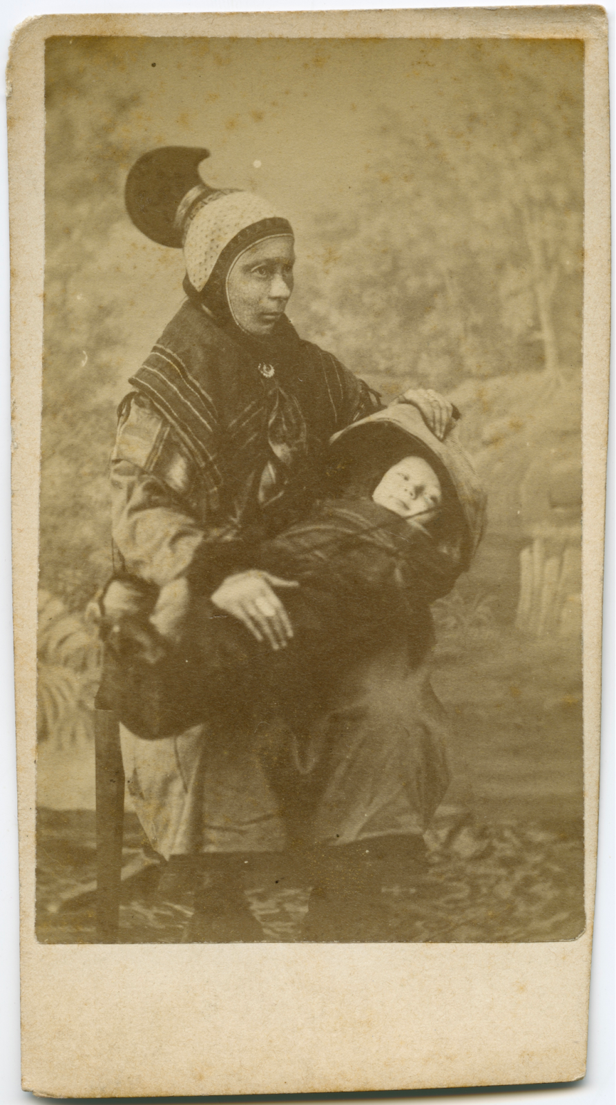 Old photo of Sami woman holding her child on her lap.